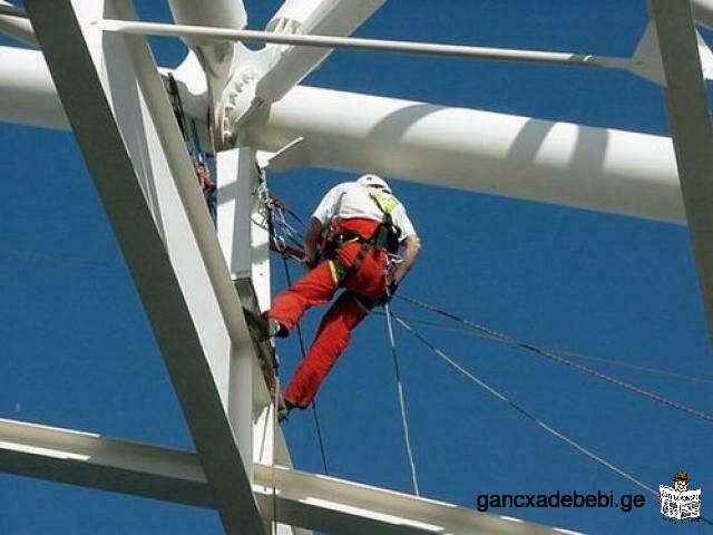 working at the height of the glass windows cleaning gutters open the door of climbers climb